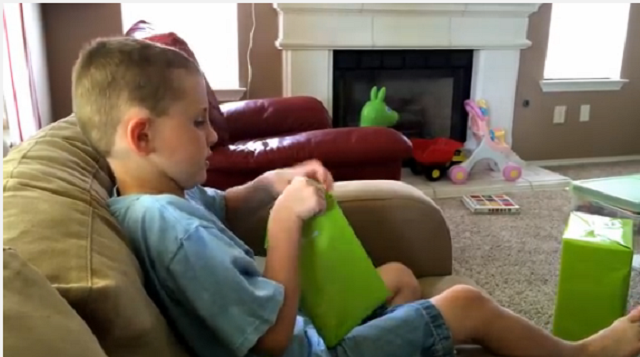 Reacción de un niño al abrir un regalo